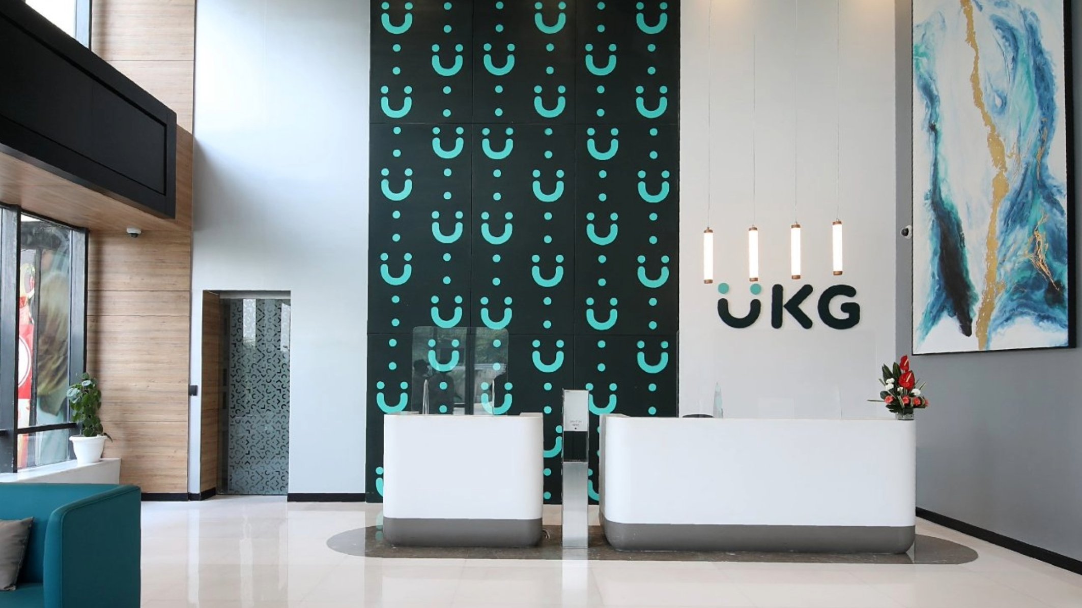 Front reception desk of UKG Building. Two white welcome areas with the UKG logo splashed on the wall behind them. 