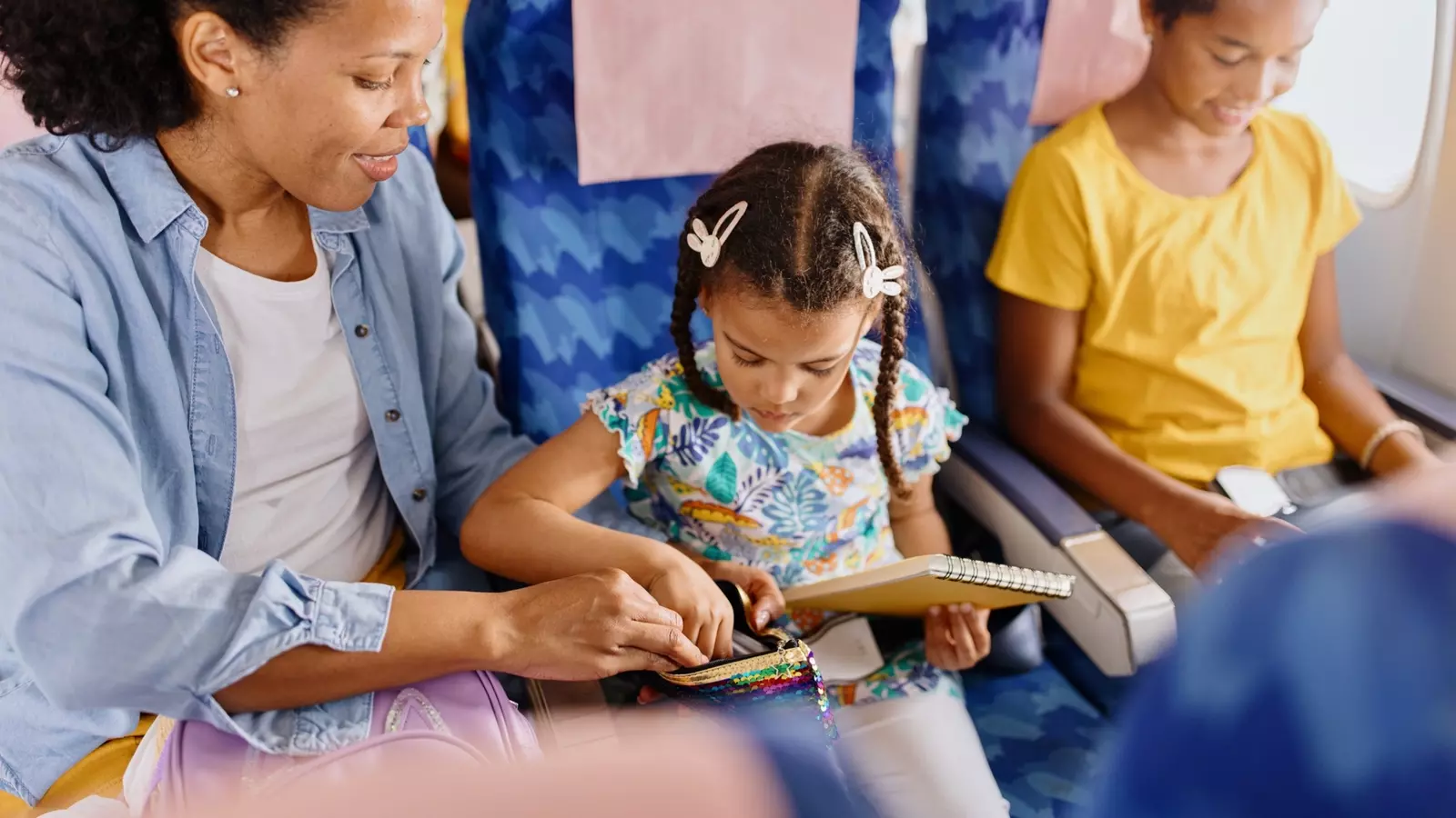 Women often volunteer to be sit between kids and be the snack-and-toys-and-tantrum-wrangler on airplane flights.