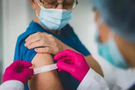 Woman receiving bandage following new vaccine mandate program