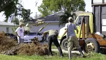 Three men assess damage after Hurricane Ian 