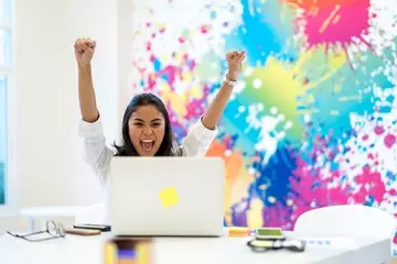 Happy HR pro at computer in office using HR technology to improve culture