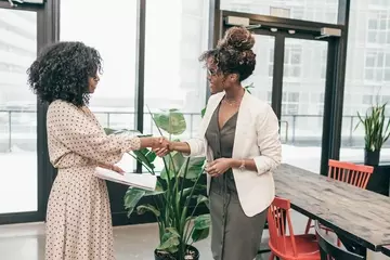 A manager welcomes a new hire to the office