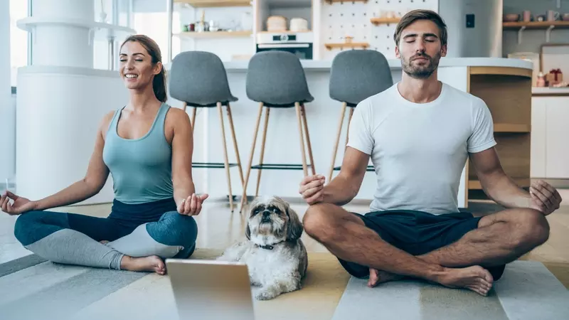 A woman and man do yoga to improve their mental health